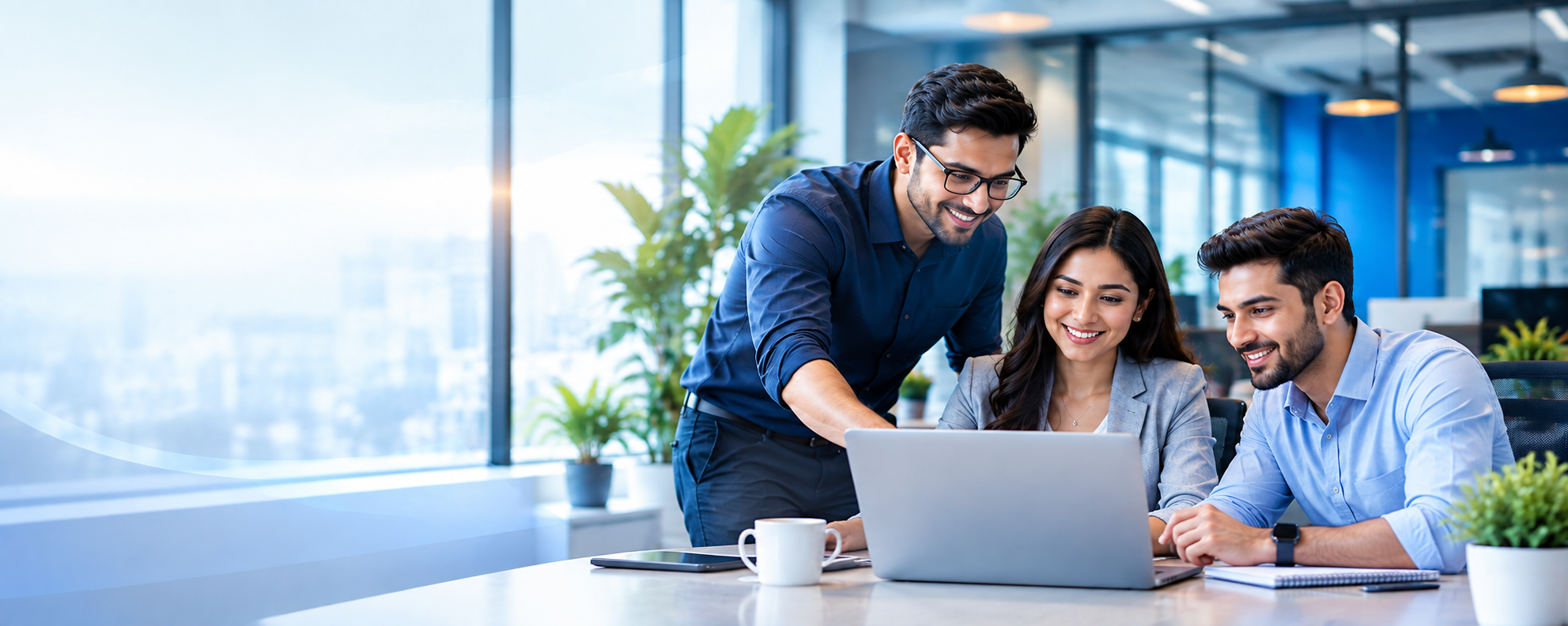 Three IT professionals working together around a laptop in a modern office